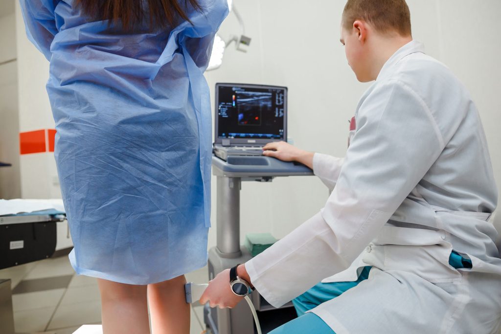 Doctor screening veins before vein treatment procedure